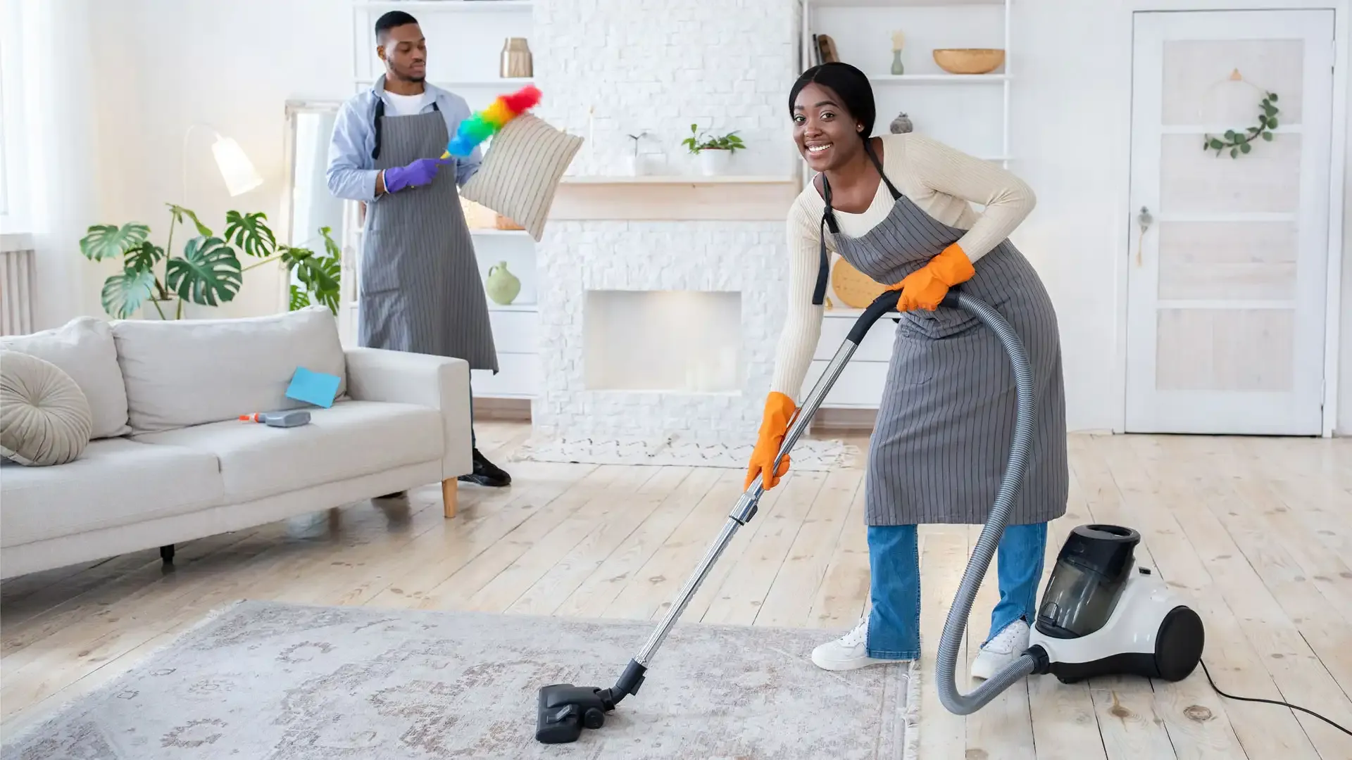 happy-black-woman-vacuuming-floor-while