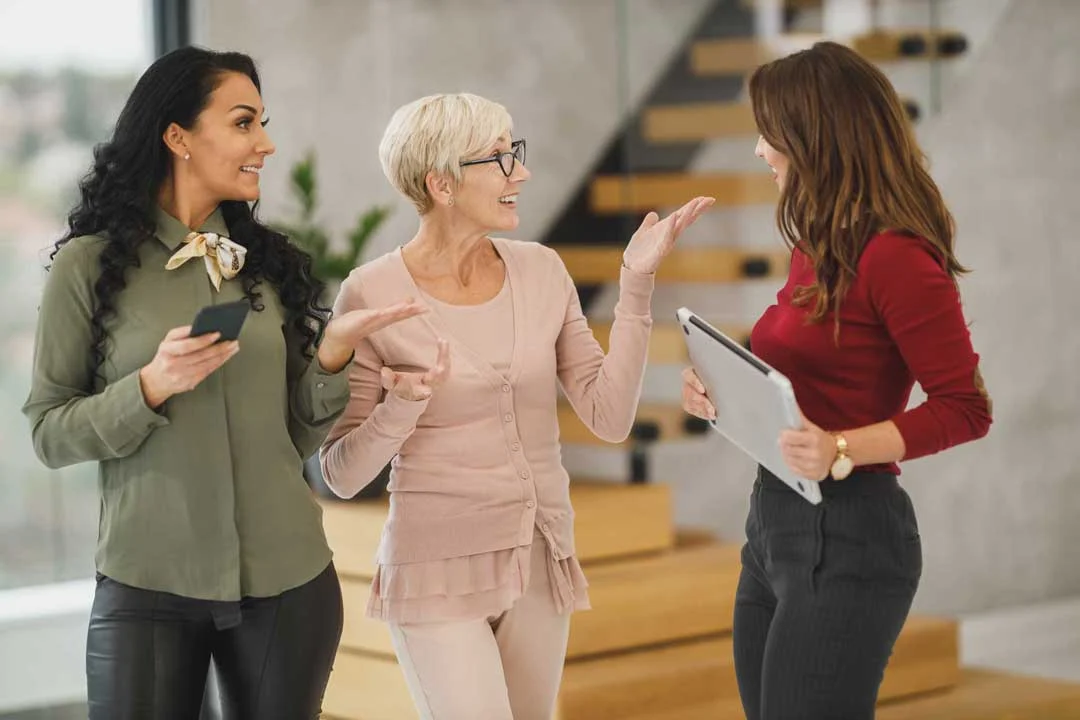 Three women in an office smiling together